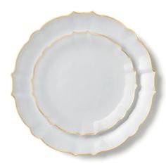 two white plates with gold trims on the rim, one is empty and the other has