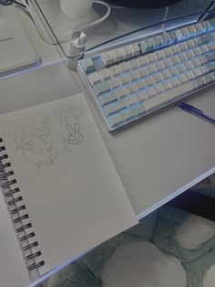 an open notebook sitting on top of a desk next to a computer keyboard and mouse