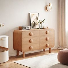 a living room with white walls and wooden furniture in the corner, along with a rug on the floor