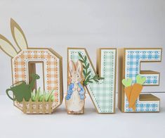 the letters are made out of wood and decorated with rabbits, carrots, and grass