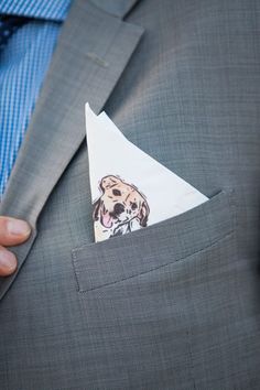 a close up of a person wearing a suit and tie with a dog on the pocket