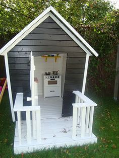 a small white shed with an oven in it