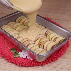 someone is pouring sauce on some cookies in a pan with red cloth and white doily