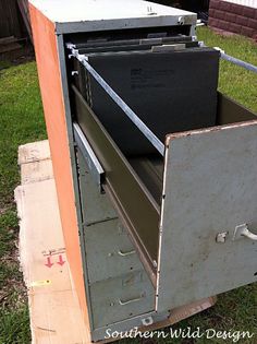 an old metal filing cabinet sitting in the grass