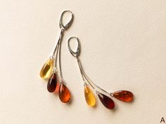 "Cherry, lemon and cognac colors amber earrings with silver for minimal jewelry admirers. Get these bright drop shape long amber earrings designed into a jewelry piece that catches every sight on the street! MATERIALS AND SIZE: Stone: 100% Natural Baltic Amber Other materials: silver 925 Weight: 5,2g (0,18 oz) Bead size: ~1,6 cm (0,62 in) x ~1 cm (0.39 in) Total earring length: ~8 cm (3,14 in) PLEASE NOTE: All our amber production is made of natural amber. Amber is an unique stone and every piec Elegant Baltic Amber Dangle Jewelry, Baltic Amber Dangle Earrings, Teardrop Baltic Amber Earrings, Modern Amber Drop Earrings, Wire Jigs, Amber Resin, Golden Logo, Earring Dangle, Cognac Color