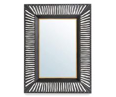 a mirror that is sitting on top of a table with a black frame and gold trim