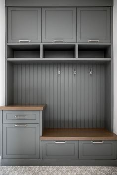 an empty room with gray cabinets and drawers