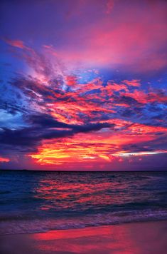 the sun is setting over the ocean and clouds