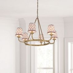 a chandelier hanging from a ceiling in a room with white walls and windows