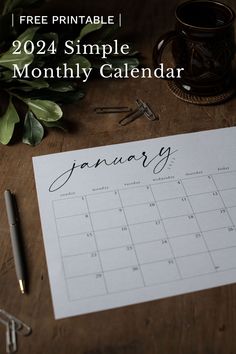 a calendar sitting on top of a wooden table next to a pen and coffee cup