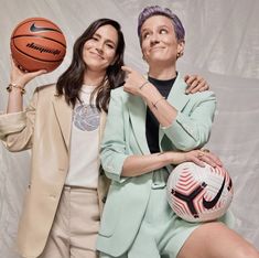 two women are posing for a photo with a basketball