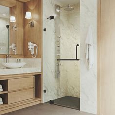 a bathroom with a walk in shower next to a white sink and wooden cabinetry