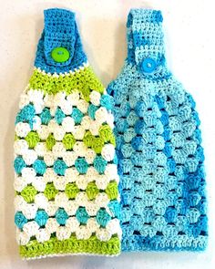 two crocheted blue and green bags sitting next to each other