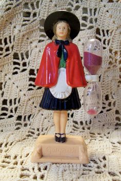 a small figurine is standing on a doily