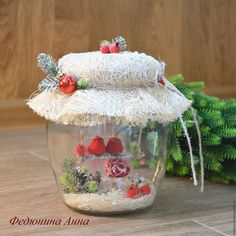 a glass jar filled with christmas decorations on top of a wooden table