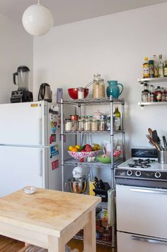 a kitchen filled with lots of clutter next to a stove top oven and refrigerator