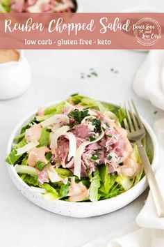 a white bowl filled with lettuce, meat and cheese on top of a table