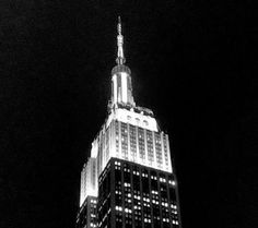 the empire building lit up at night in black and white