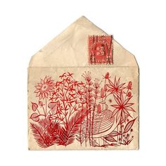 an old envelope with red ink on it and flowers in the front, sitting on a white surface