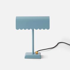 a blue table lamp with a black cord attached to the base and a yellow light plugged into it