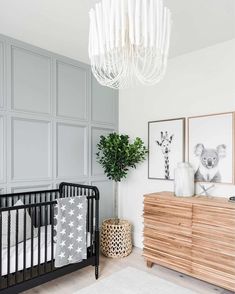 a baby's room with a crib, dresser and chandelier in it