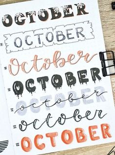 an open notebook with the words october written in orange and black ink on top of it