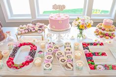 a table topped with lots of different types of cakes and cupcakes on top of it