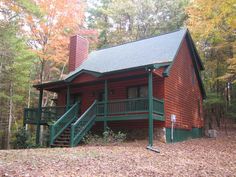 a log cabin in the woods with stairs leading up to it's second floor