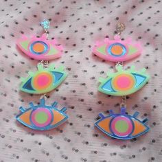 These awesome statement earrings are super colorful and fun! They're sure to upgrade your jewelry collection.*The design was laser cut from 1/8" inch thick acrylic.*The charms were cut from mirror blue, bright pink, sherbet, and frosted green acrylic.*Each earring contains three various color combinations.*They are lightweight, and were attached to a circular acrylic earring post with a surgical steel stud.*These can be personalized with earring posts, ear wire, or wrap around hooks for stretche Fun Neon Earrings For Gifts, Playful Bright Colored Jewelry Gift, Edgy Outfit, Weird Jewelry, Quirky Earrings, Laser Cut Jewelry, Funky Earrings, Funky Jewelry, Acrylic Earrings