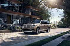 an suv is parked in front of a house on a sunny day with the sun shining