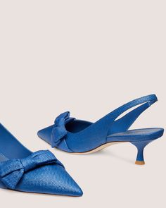 a pair of blue shoes with a bow on the heel