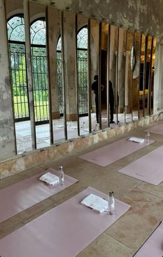 there are many pink yoga mats on the floor in front of large mirrors and windows