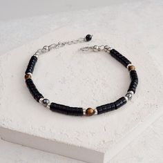 Black Stone Bracelet, Onyx, Tigers Eye and Hematite Protection Healing Crystal Bracelet. This great everyday stackable slim bracelet is made with Black Onyx heishi beads, which are separated by Sterling Silver spacers and Tiger's Eye and Hematite beads. Fastened with our signature Stainless Steel hook and adjustable chain fastening, making a luxurious strong and wearable and waterproof bracelet for men or women, that you won't want to take off.  Onyx - Is a stone of protection, strength and focu Modern Beaded Bracelet With Black Beads As Gift, Minimalist Silver Beaded Bracelet With Black Beads, Modern Black Beads Bracelets As Gift, Minimalist Hematite Round Bead Jewelry, Modern Black Beads Bracelet As Gift, Modern Black Beaded Bracelets As Gift, Modern Handmade Beaded Bracelets With Round Beads, Modern Black Beaded Bracelet For Gift, Minimalist Black Beaded Bracelets