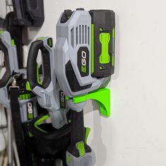 a green and gray tool holder on the wall