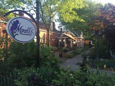 there is a sign that says mandel's in front of some trees and bushes