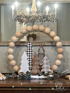 a wooden christmas tree sitting on top of a table next to a mirror and lights