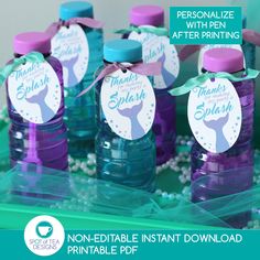 purple and blue water bottles with thank you're here tags on them for mermaid party favors