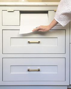 a person holding a piece of paper in their left hand and pulling it out of the drawer