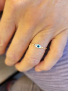 Sweet and dainty evil eye ring. Available in gold, rose gold, or Sterling silver.  Genuine mother of pearl Hand wired with love! This sweet little evil eye bead is approx 3mm with gold filled, rose gold filled, or Sterling silver.  Sweet and charming! If you like dainty jewelry, you will love ❤ this ring! The evil eye is a term used to describe the process of being afflicted by Raja-Tama vibrations from another person, which means that the other person can afflict us with the evil eye intentiona 14k Gold Ring With Diamond Eyes, Fine Jewelry Featuring Evil Eye, Minimalist Round Evil Eye Jewelry, 14k Gold Evil Eye Ring, Dainty 14k Gold Jewelry With Diamond Eyes, Dainty Wedding Jewelry With Diamond Eyes, Sterling Silver Evil Eye Ring, White Evil Eye Ring Jewelry, White Evil Eye Ring