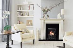 a living room filled with furniture and a fire place in the middle of the room