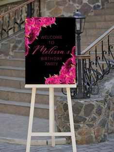 a welcome sign stands in front of some stairs and steps with pink flowers on it