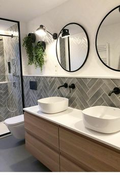 a bathroom with two sinks and mirrors on the wall above them is decorated in black and white