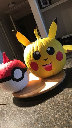 two paper mache pikachu pumpkins sitting next to each other