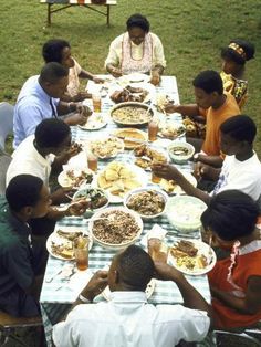 a group of people sitting around a table eating food