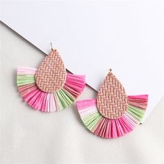 A statement pair of drop earrings featuring woven raffia and vibrant fringe. 3.94" W x 3.35" L 18k gold-plated copper / polystyrene / raffia Spring Beach Tassel Earrings, Multicolor Tassel Earrings For Summer Beach, Multicolor Tassel Earrings For Beach In Spring, Spring Beach Tassel Drop Earrings, Summer Beach Tassel Earrings With Fringe, Summer Beach Fringe Earrings, Spring Beach Earrings With Fringe, Multicolor Fringe Tassel Earrings For The Beach, Spring Vacation Woven Jewelry