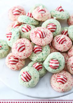 a white plate topped with green and red sprinkle covered donuts