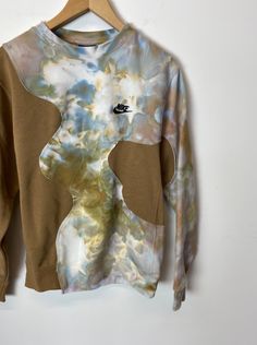 a tie dye sweatshirt hanging on a hanger