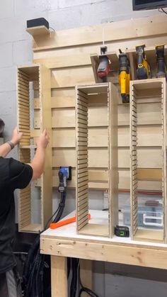 a man is working on some wooden shelves