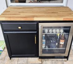 an empty mini fridge is in the middle of a kitchen counter with its door open