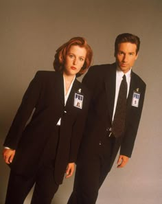 two people in suits and ties standing next to each other